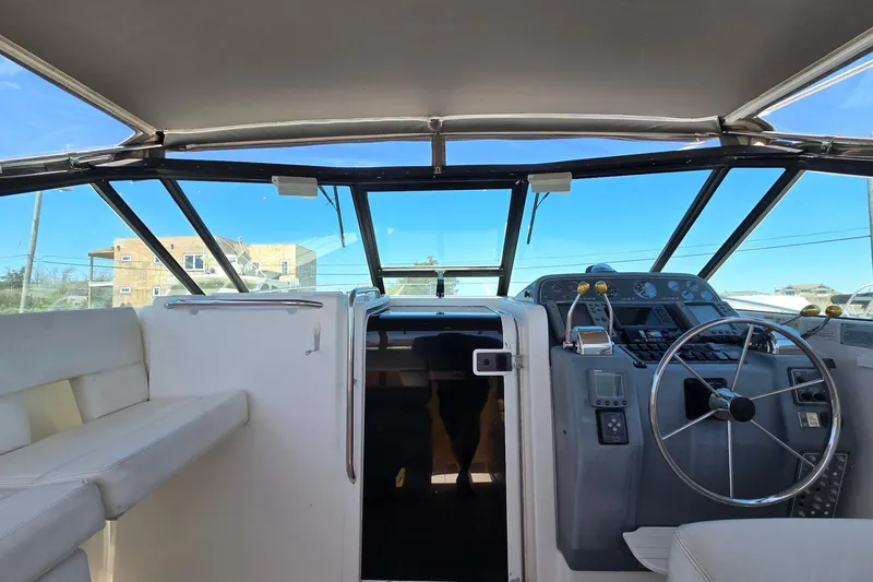 Slide: The Image of 1999 Tiara Yachts 3100 Open cockpit with steering wheel and control panel. - 10