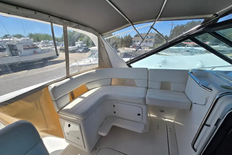 Slide: The Image of Interior view of a 1999 Tiara Yachts 3100 Open, featuring white seating and windows. - 11