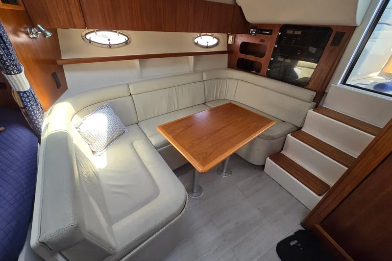 Slide: The Image of 1999 Tiara Yachts 3100 Open interior with cozy seating and wooden table. - 14