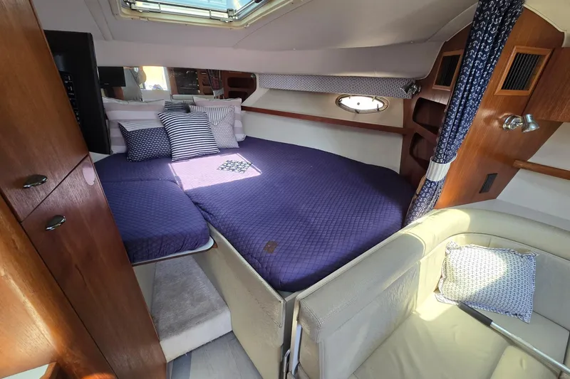 Slide: The Image of Cozy cabin interior of 1999 Tiara Yachts 3100 Open with plush bedding and nautical decor. - 15