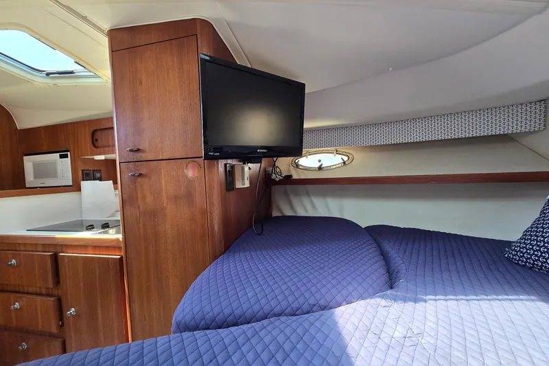 Slide: The Image of Interior of 1999 Tiara Yachts 3100 Open with bed, TV, and kitchenette. - 18