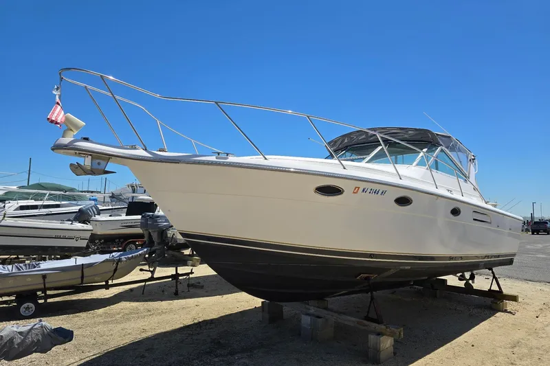 Slide: The Image of 1999 Tiara Yachts 3100 Open boat on dry dock under clear blue sky. - 2