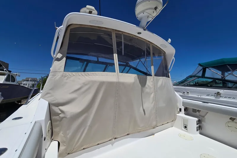 Slide: The Image of 1999 Tiara Yachts 3100 Open with covered cockpit, docked under clear blue sky. - 6