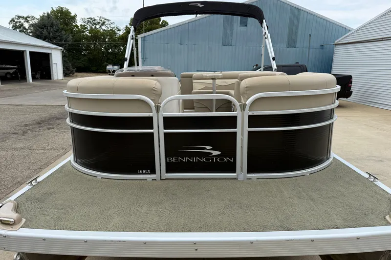 Slide: The Image of 2015 Bennington 18 SLX pontoon boat with beige seating and black exterior. - 7