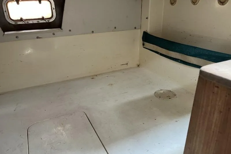 Slide: The Image of Interior cabin of a 1995 Mako 293 Walk Around boat, featuring a small window. - 9