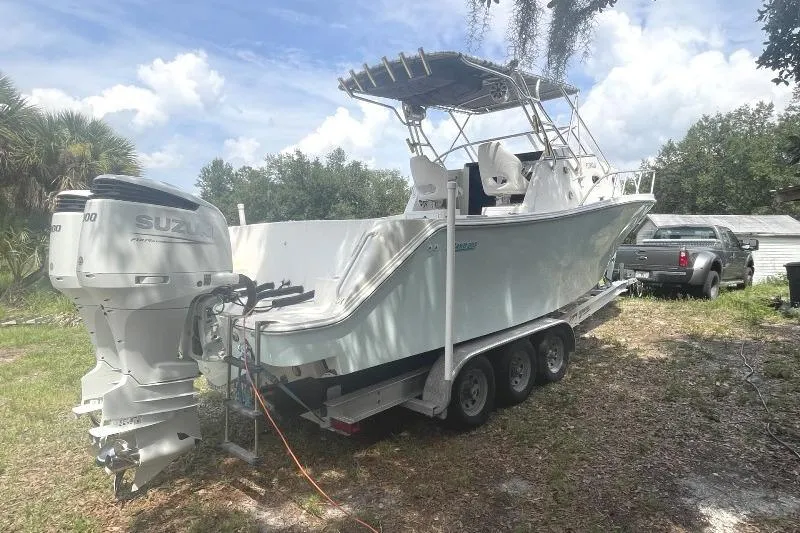 Slide: The Image of 1995 Mako 293 Walk Around boat on trailer with Suzuki outboard engines. - 2