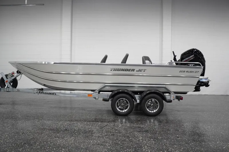 The Image of 2026 Thunder Jet 209 Rush OT boat on trailer, side view in showroom. - 1
