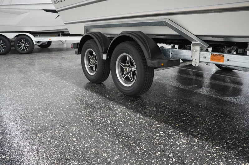 Slide: The Image of Trailer of 2026 Thunder Jet 209 Rush OT boat on wet pavement. - 10