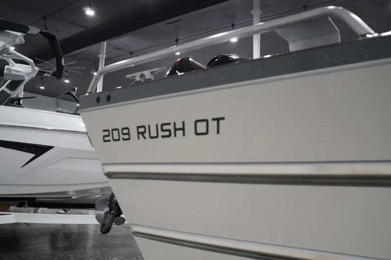 Slide: The Image of 2026 Thunder Jet 209 Rush OT boat displayed in showroom. - 11