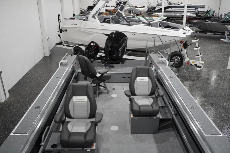 Slide: The Image of 2026 Thunder Jet 209 Rush OT boat interior with seating and motor, displayed in showroom. - 29