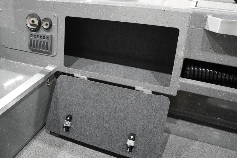 Slide: The Image of Interior storage compartment of 2026 Thunder Jet 209 Rush OT boat, featuring gauges and switches. - 48
