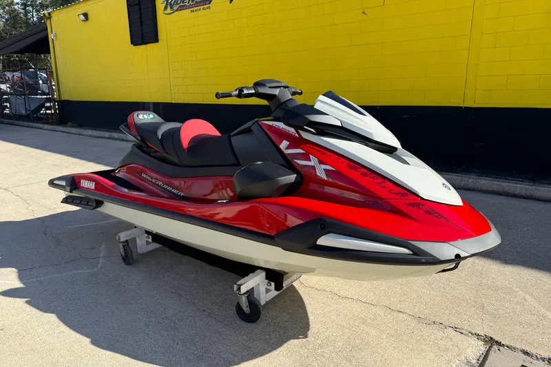 Slide: The Image of 2026 Yamaha WaveRunner VX Cruiser in vibrant red, parked outdoors near a yellow building. - 4