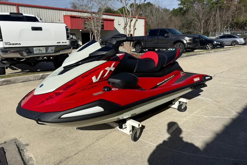 Slide: The Image of 2026 Yamaha WaveRunner VX Cruiser in red and white, parked outdoors on a sunny day. - 6