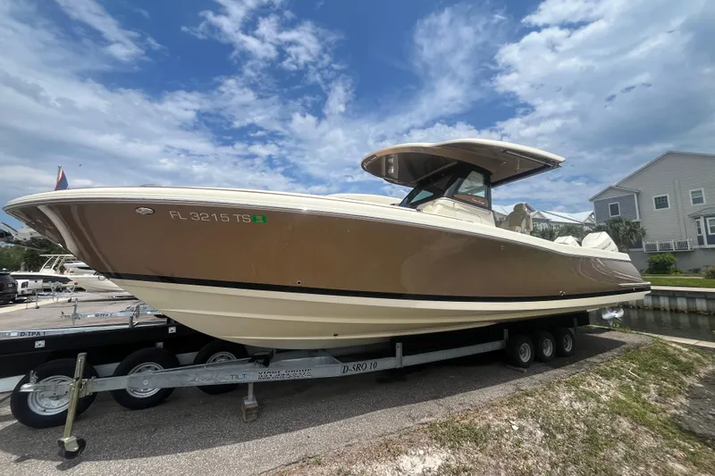The Image of 2024 Chris-Craft Catalina 30 boat on trailer under a partly cloudy sky. - 0