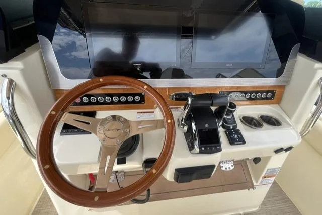 Slide: The Image of 2024 Chris-Craft Catalina 30 helm with wooden steering wheel and modern controls. - 11