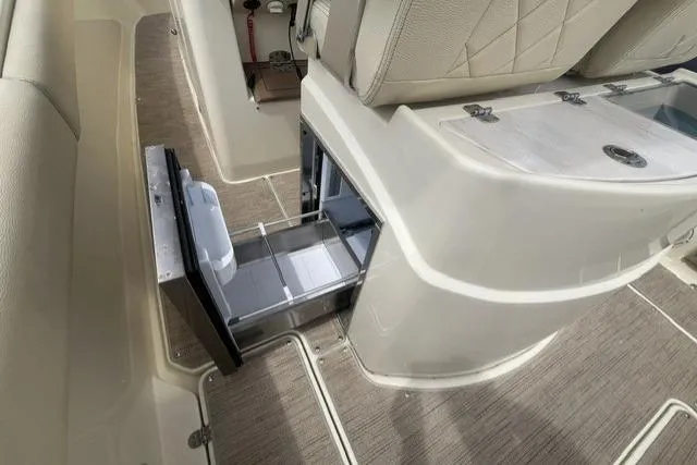Slide: The Image of 2024 Chris-Craft Catalina 30 interior with open storage compartment and beige seating. - 19