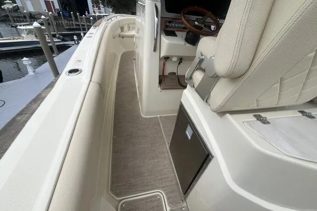 Slide: The Image of 2024 Chris-Craft Catalina 30 boat interior with beige seating and steering wheel. - 20