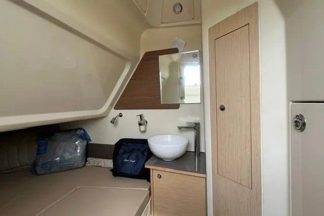 Slide: The Image of 2024 Chris-Craft Catalina 30 cabin interior with sink, mirror, and storage. - 27