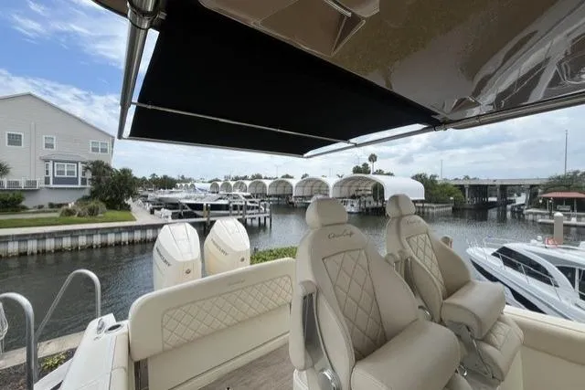 Slide: The Image of 2024 Chris-Craft Catalina 30 boat with luxurious seating, docked near waterfront homes. - 28