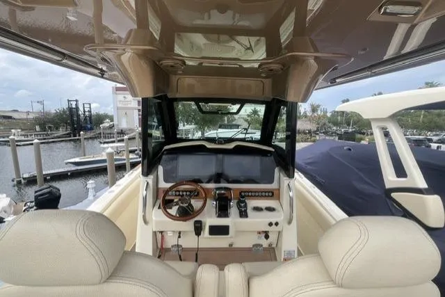 Slide: The Image of 2024 Chris-Craft Catalina 30 helm with dual screens and leather seats at marina. - 3