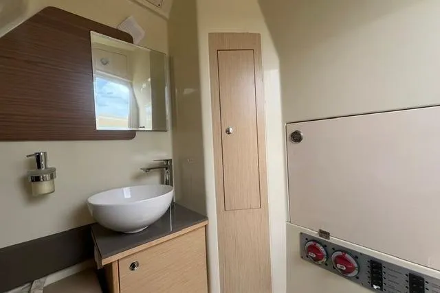 Slide: The Image of 2024 Chris-Craft Catalina 30 interior bathroom with modern sink and wooden cabinetry. - 6