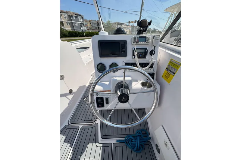 Slide: The Image of 2016 PROLINE 23DC boat helm with steering wheel, navigation controls, and marine electronics. - 10