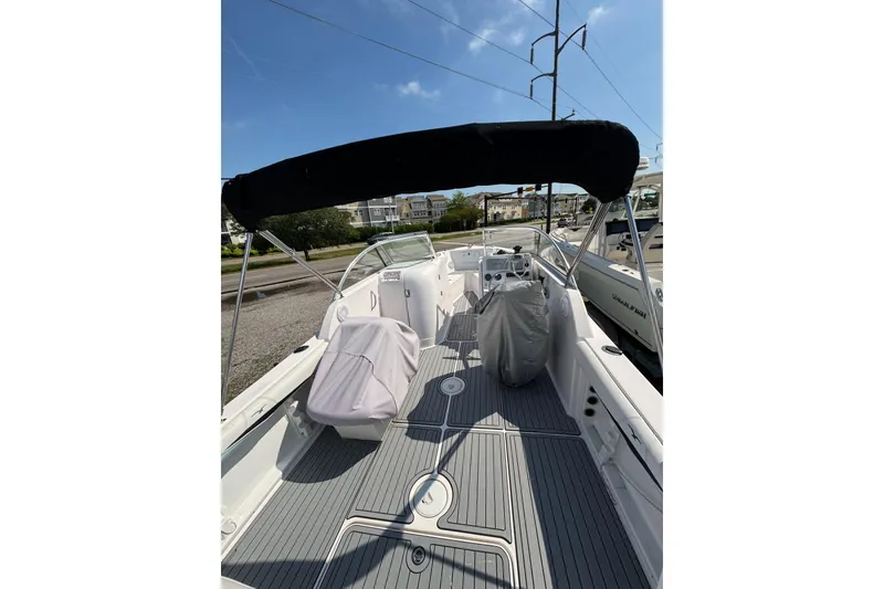Slide: The Image of 2016 PROLINE 23DC boat interior with covered seating and canopy under clear blue sky. - 14
