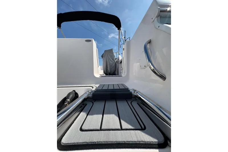 Slide: The Image of 2016 PROLINE 23DC boat interior with sleek flooring and stainless steel handrails under a clear sky. - 15