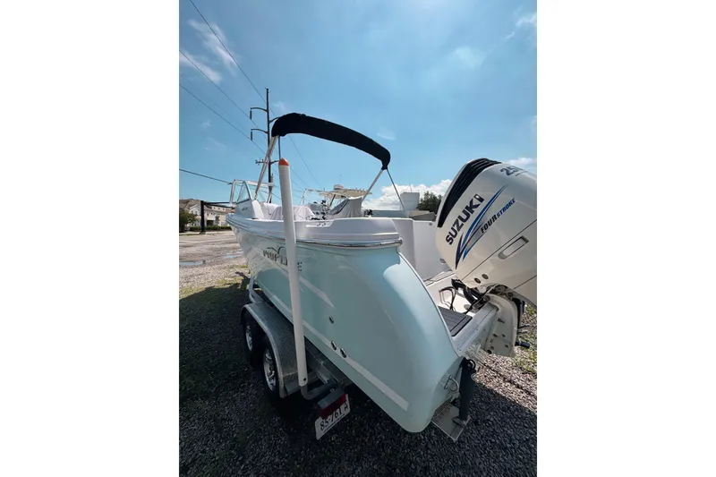 Slide: The Image of 2016 PROLINE 23DC boat with Suzuki outboard motor on trailer under clear sky. - 16
