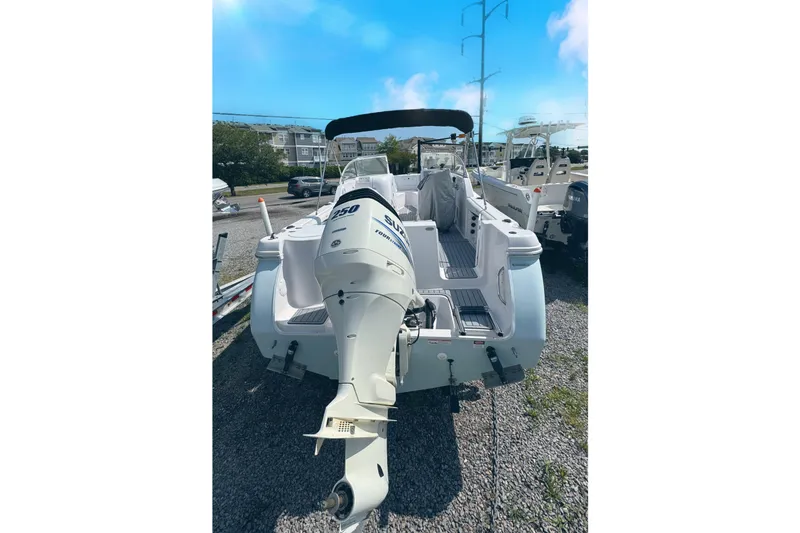 Slide: The Image of 2016 PROLINE 23DC boat with powerful outboard motor, parked on gravel lot under clear sky. - 17