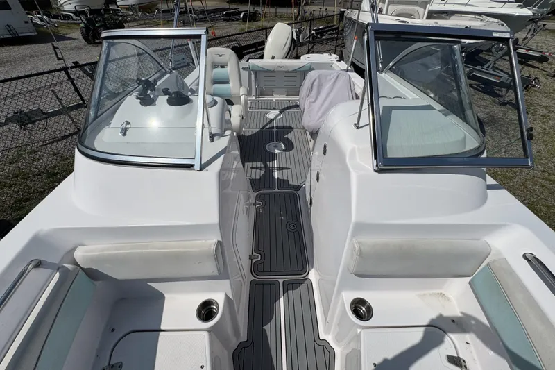 Slide: The Image of 2016 PROLINE 23DC boat interior with seating and open windshield, docked outdoors. - 3
