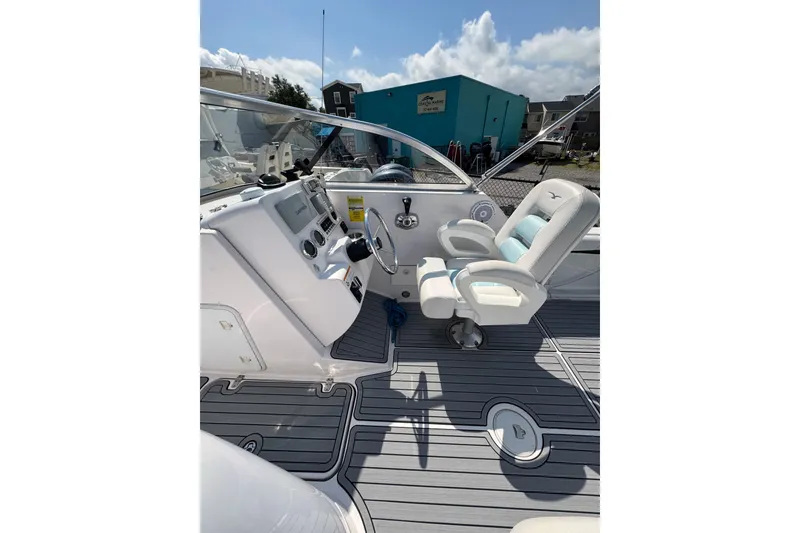Slide: The Image of 2016 PROLINE 23DC boat cockpit with steering wheel and cushioned captain's chair. - 7