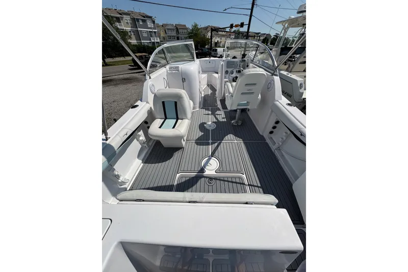 Slide: The Image of 2016 PROLINE 23DC boat interior with seating and steering, docked outdoors. - 8