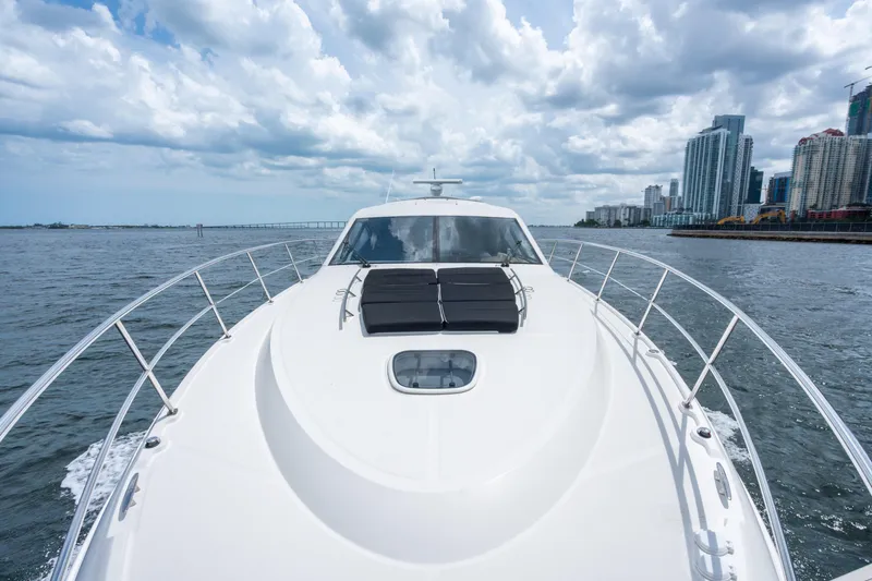 Slide: The Image of 2017 Sea Ray Sundancer 510 yacht cruising near city skyline under cloudy sky. - 15