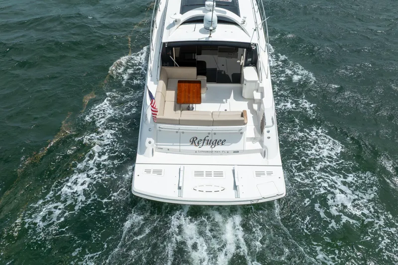 Slide: The Image of 2017 Sea Ray Sundancer 510 yacht cruising on open water, rear view. - 6