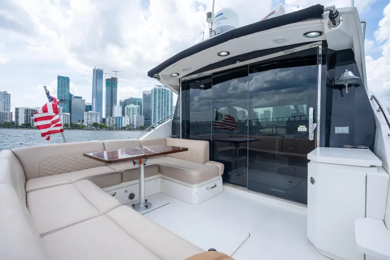Slide: The Image of Luxurious 2017 Sea Ray Sundancer 510 yacht with city skyline backdrop and elegant seating area. - 9