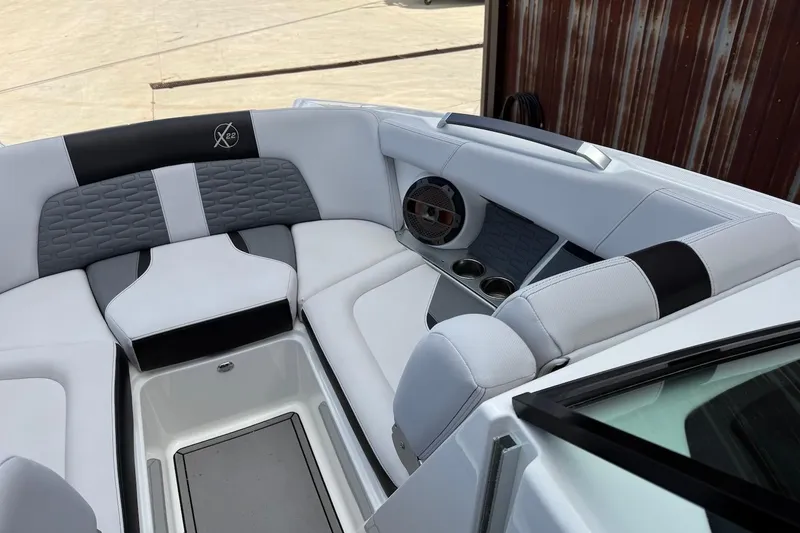 Slide: The Image of 2019 MasterCraft X22 boat interior with cushioned seating and speaker system. - 11