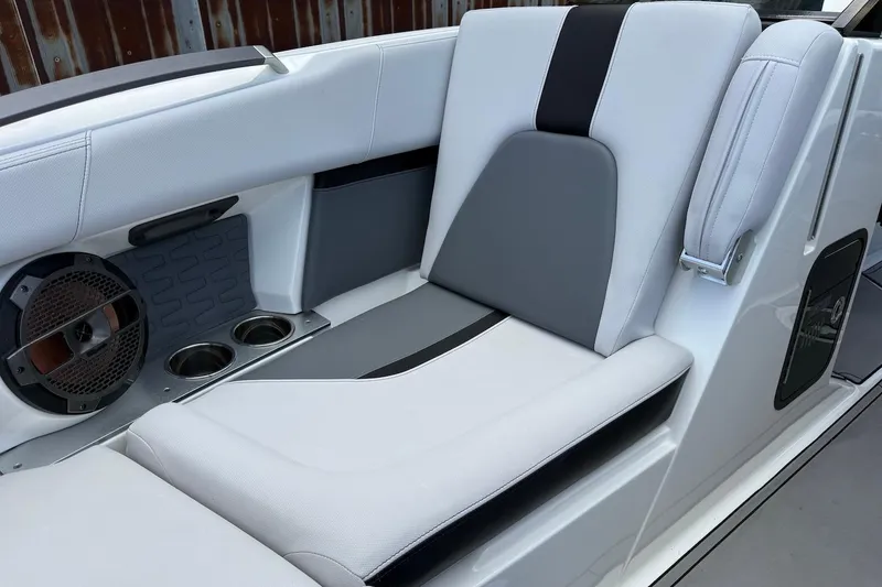 Slide: The Image of 2019 MasterCraft X22 boat interior with sleek seating, speaker, and cup holders. - 12