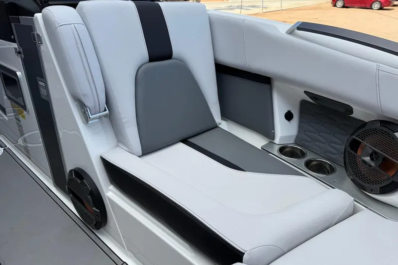 Slide: The Image of 2019 MasterCraft X22 boat interior with sleek seating and built-in cup holders. - 13