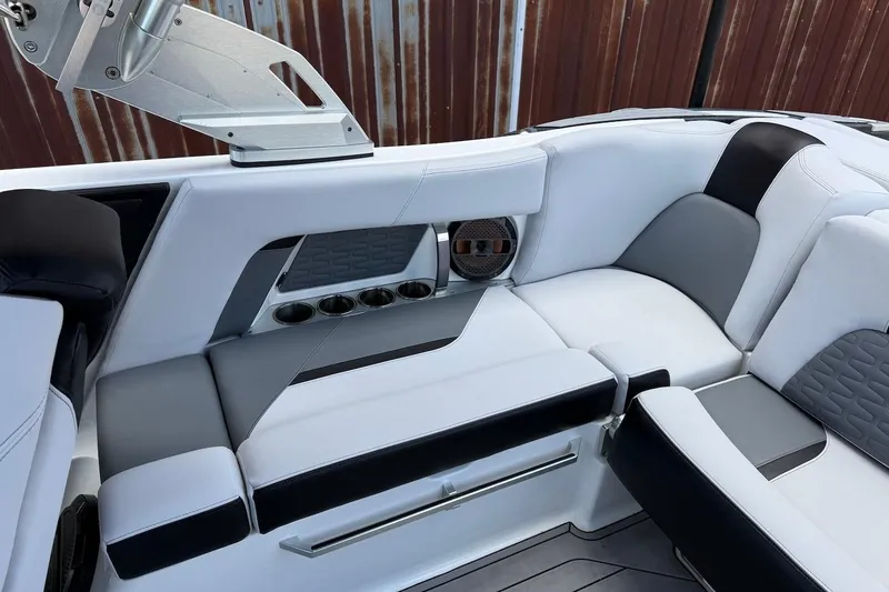 Slide: The Image of 2019 MasterCraft X22 boat interior with sleek white and gray seating and cup holders. - 16