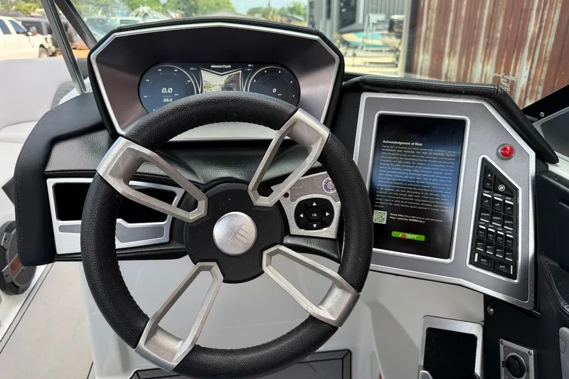 Slide: The Image of Steering wheel and dashboard of a 2019 MasterCraft X22 boat, featuring modern controls and display. - 7