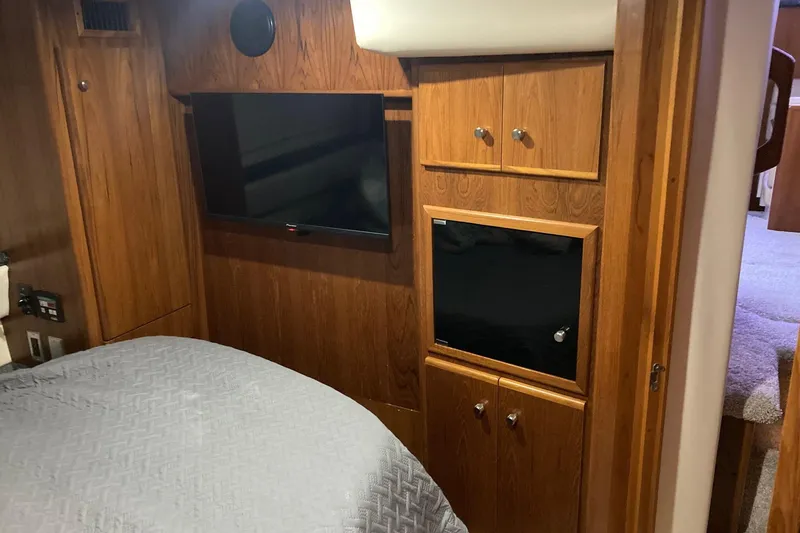 Slide: The Image of Interior of 2001 Carver 356 Motor Yacht with wood paneling and mounted TV. - 11