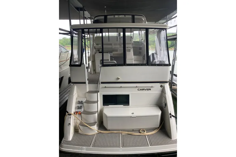Slide: The Image of 2001 Carver 356 Motor Yacht docked, rear view showing deck and cabin entrance. - 2