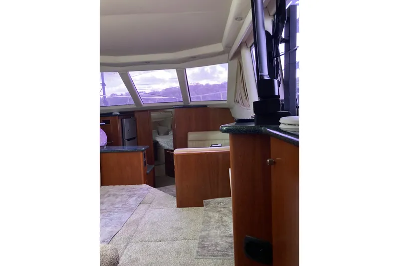 Slide: The Image of Interior of 2001 Carver 356 Motor Yacht with wood finishes and large windows. - 9