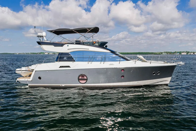 Slide: The Image of 2017 Monte Carlo Yachts MC5 cruising on open water under a partly cloudy sky. - 17