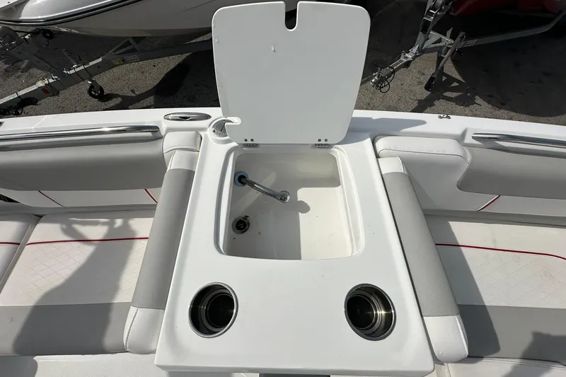 Slide: The Image of 2021 Tahoe 2150 boat interior with open storage compartment and cup holders. - 10
