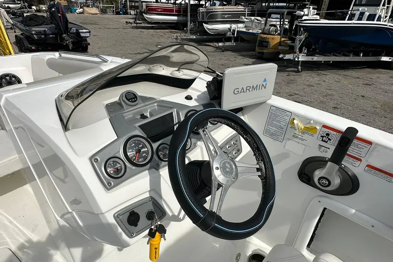 Slide: The Image of 2021 Tahoe 2150 boat dashboard with Garmin navigation system and steering wheel. - 12