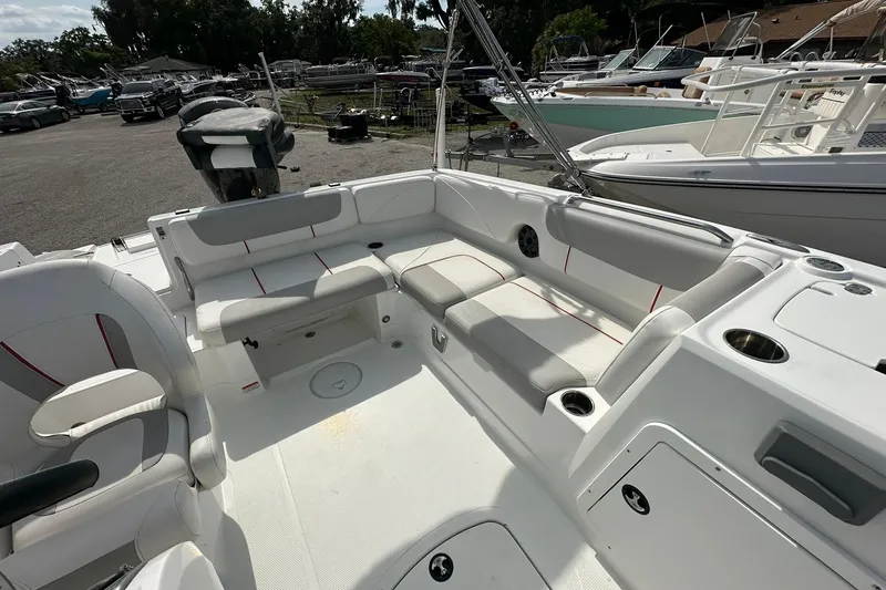 Slide: The Image of 2021 Tahoe 2150 boat interior with spacious seating and modern design in a marina setting. - 14