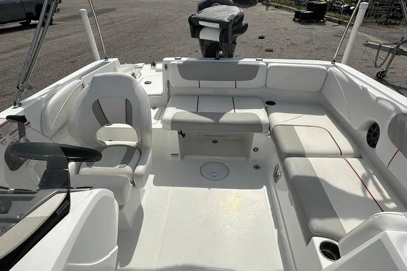 Slide: The Image of Interior of a 2021 Tahoe 2150 boat with white seating and steering console. - 18
