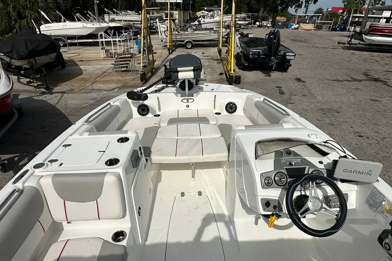 Slide: The Image of 2021 Tahoe 2150 boat interior with Garmin navigation, docked at a marina. - 19